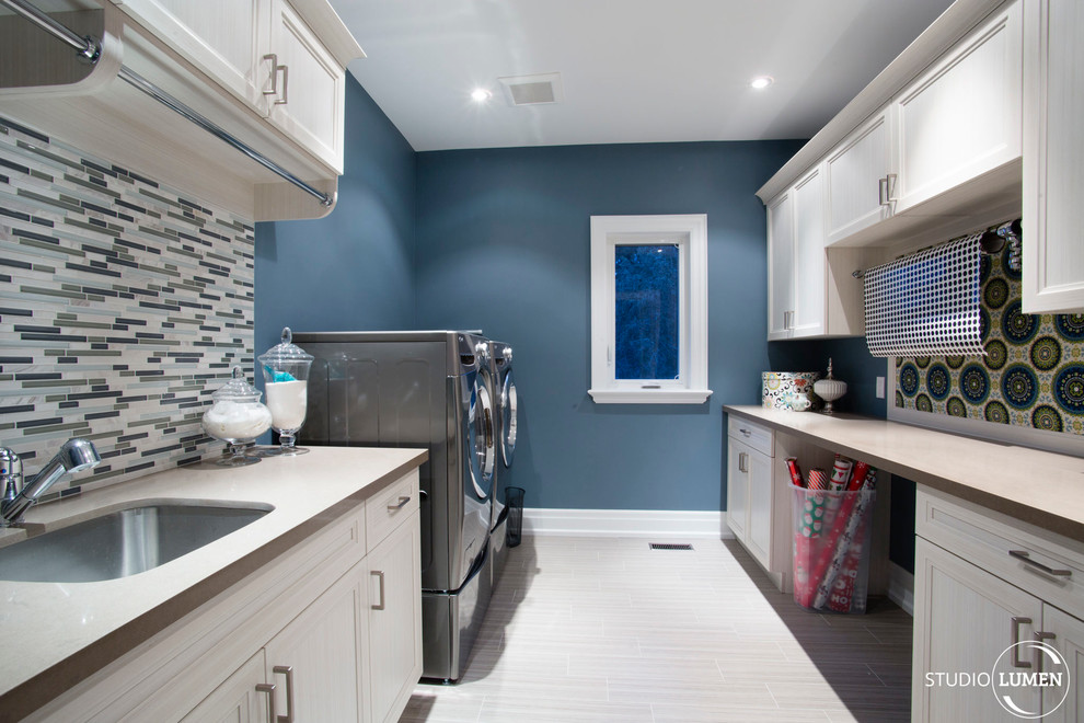 Inspiration för moderna grovkök, med en enkel diskho, marmorbänkskiva, blå väggar och en tvättmaskin och torktumlare bredvid varandra
