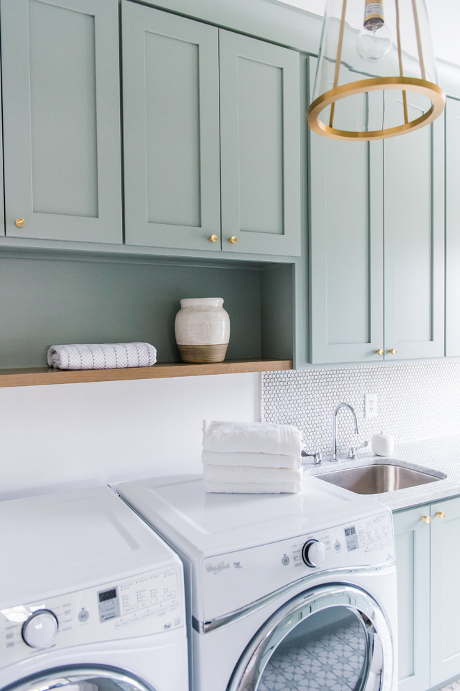 Idéer för en mellanstor amerikansk parallell tvättstuga enbart för tvätt, med en nedsänkt diskho, skåp i shakerstil, gröna skåp, marmorbänkskiva, vita väggar, betonggolv och en tvättmaskin och torktumlare bredvid varandra