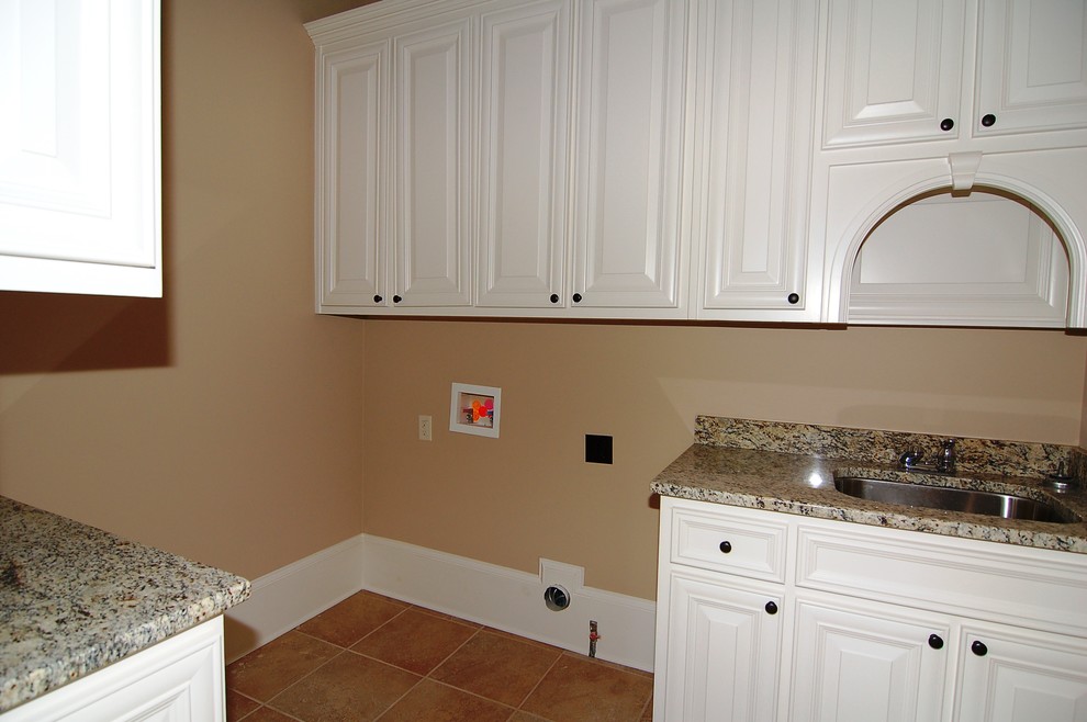 Design ideas for a large traditional galley separated utility room in Orange County with a submerged sink, raised-panel cabinets, white cabinets, granite worktops, beige walls, ceramic flooring and a side by side washer and dryer.