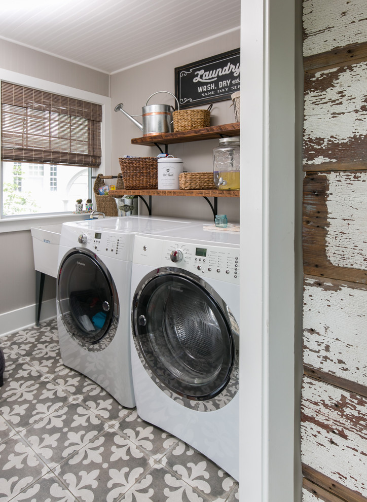 Immagine di una sala lavanderia country con lavatoio, lavatrice e asciugatrice affiancate, pavimento grigio e pareti grigie