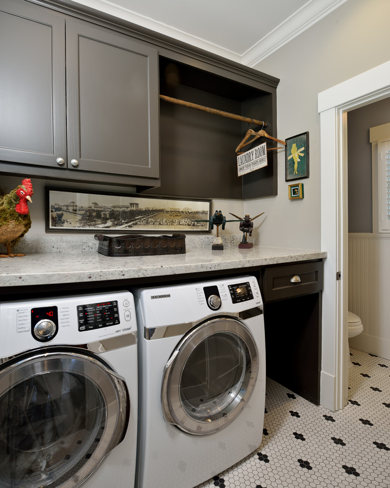 Immagine di una piccola lavanderia multiuso american style con ante lisce, ante grigie, top in granito, pareti grigie, pavimento con piastrelle in ceramica e lavatrice e asciugatrice affiancate