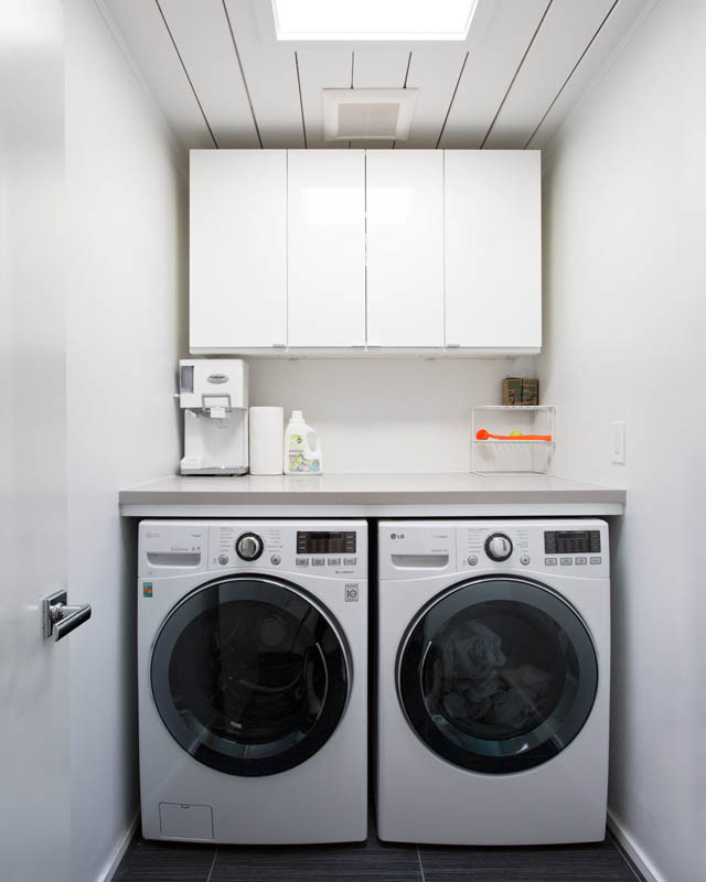 Esempio di una piccola lavanderia minimalista con ante lisce, ante bianche, pareti bianche e lavatrice e asciugatrice affiancate