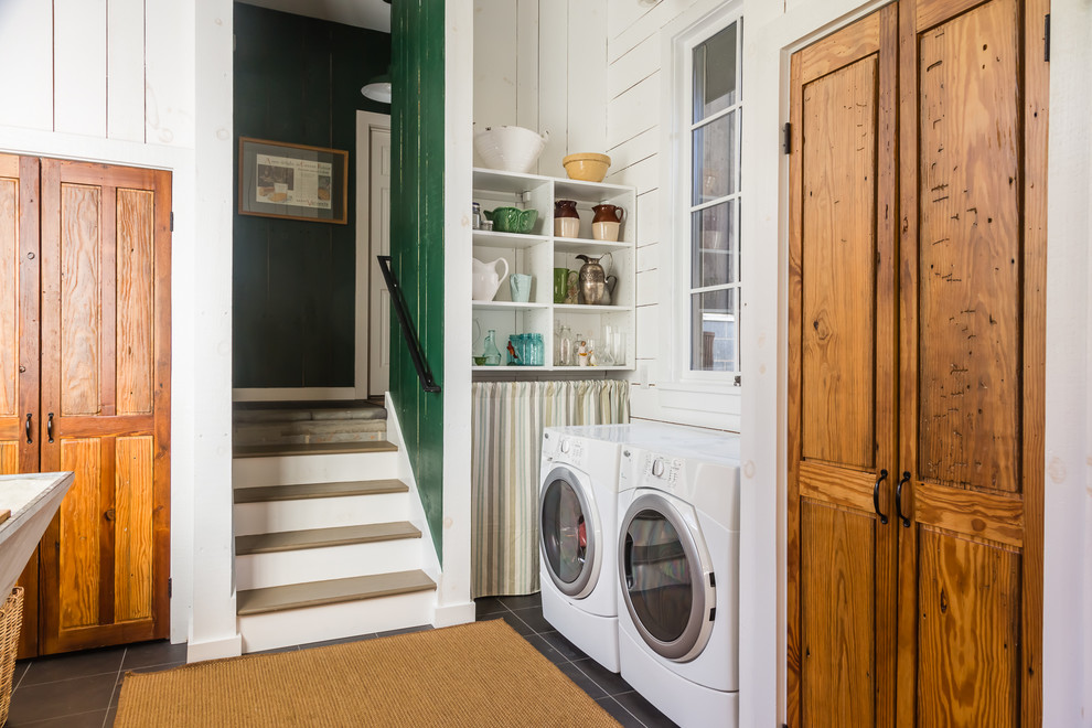 Idee per una lavanderia multiuso tradizionale di medie dimensioni con pavimento con piastrelle in ceramica, lavatrice e asciugatrice affiancate, ante in legno scuro e pareti bianche