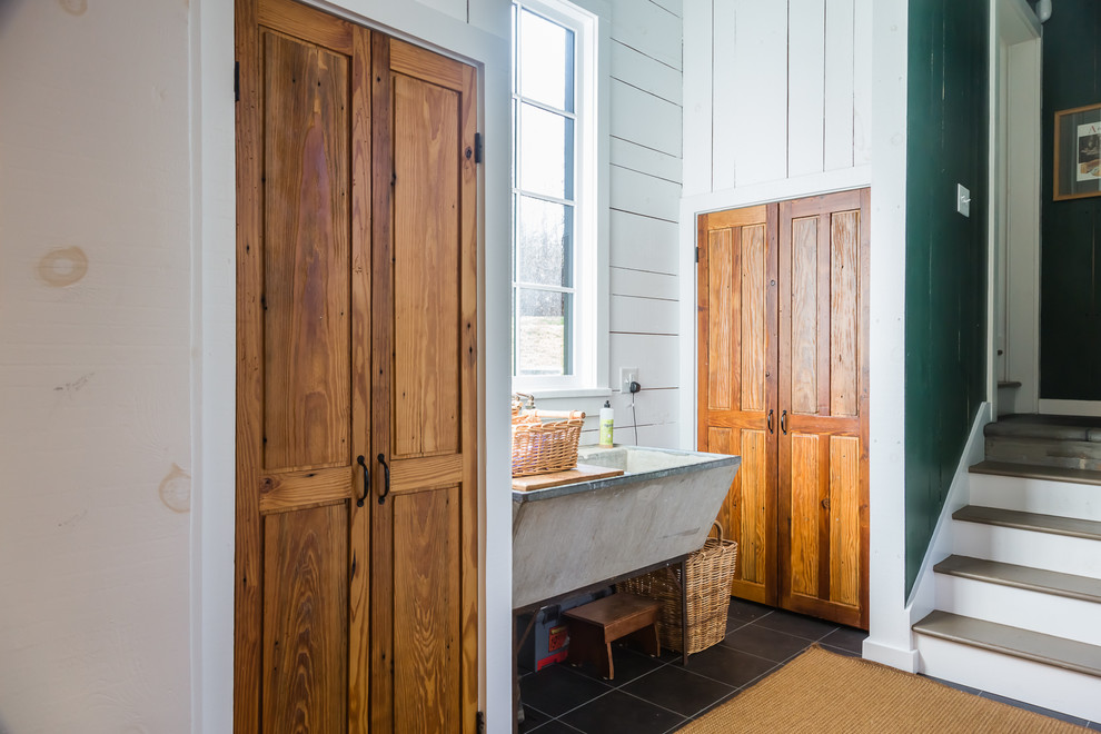 Mittelgroßer Klassischer Hauswirtschaftsraum mit hellbraunen Holzschränken, Keramikboden, Waschmaschine und Trockner nebeneinander und weißer Wandfarbe in Raleigh
