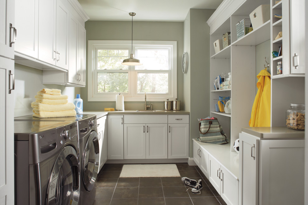 Imagen de lavadero clásico renovado con puertas de armario blancas y suelo gris