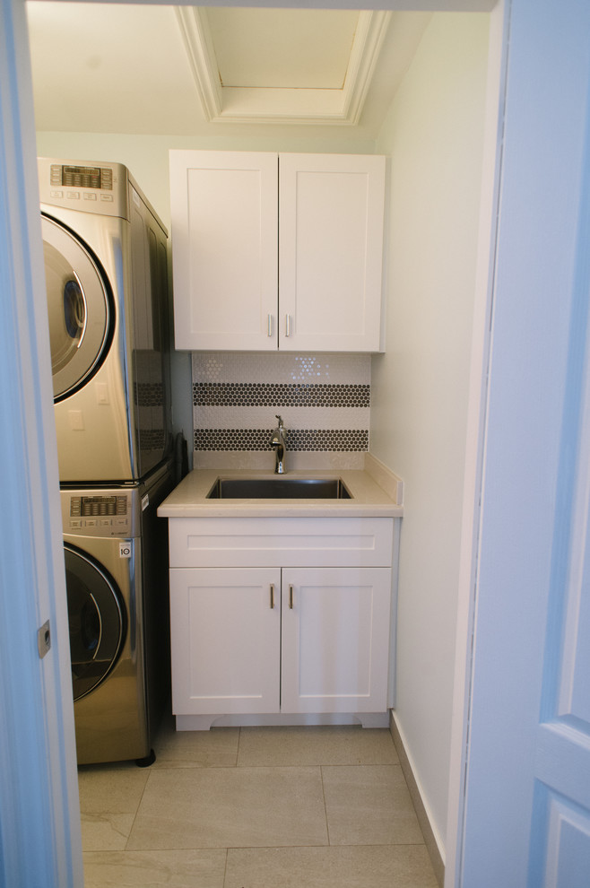 Einzeilige, Kleine Klassische Waschküche mit Waschbecken, Schrankfronten im Shaker-Stil, weißen Schränken, Quarzwerkstein-Arbeitsplatte, blauer Wandfarbe, Porzellan-Bodenfliesen, Waschmaschine und Trockner gestapelt und grauem Boden in Toronto