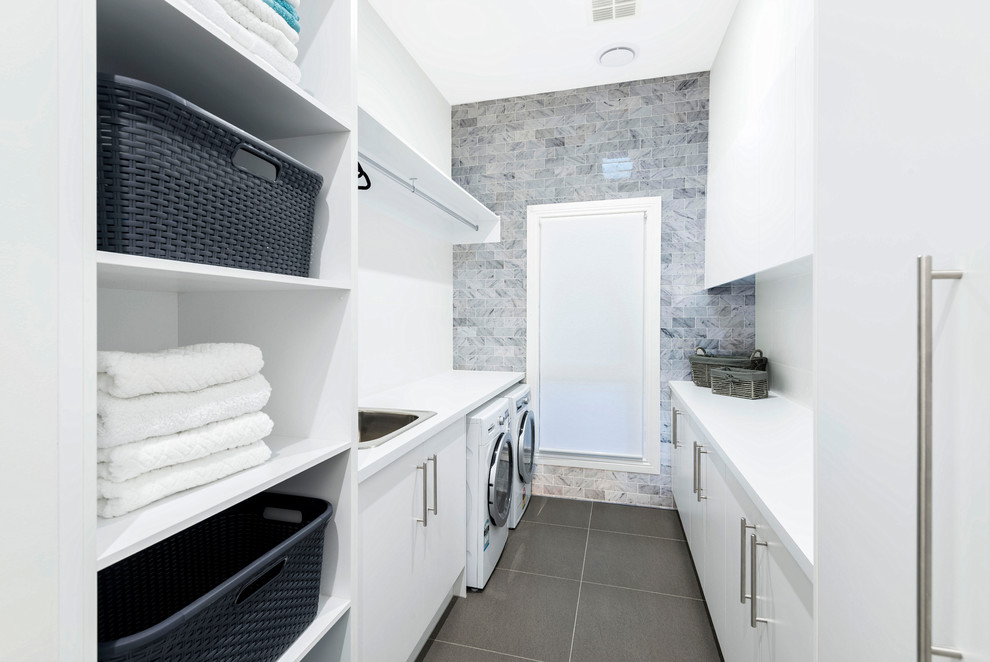 メルボルンにある高級な小さなコンテンポラリースタイルのおしゃれな洗濯室 (ll型、ドロップインシンク、白い壁、セラミックタイルの床、フラットパネル扉のキャビネット、白いキャビネット、左右配置の洗濯機・乾燥機) の写真
