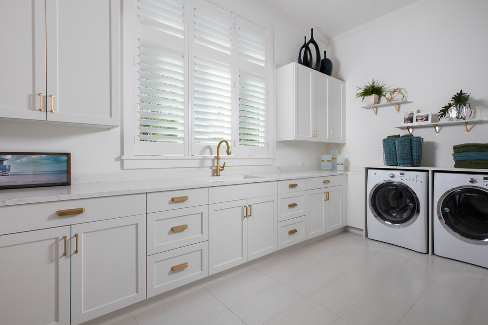Diseño de lavadero en L clásico renovado con fregadero bajoencimera, armarios estilo shaker, puertas de armario blancas, paredes blancas, suelo blanco y encimeras blancas