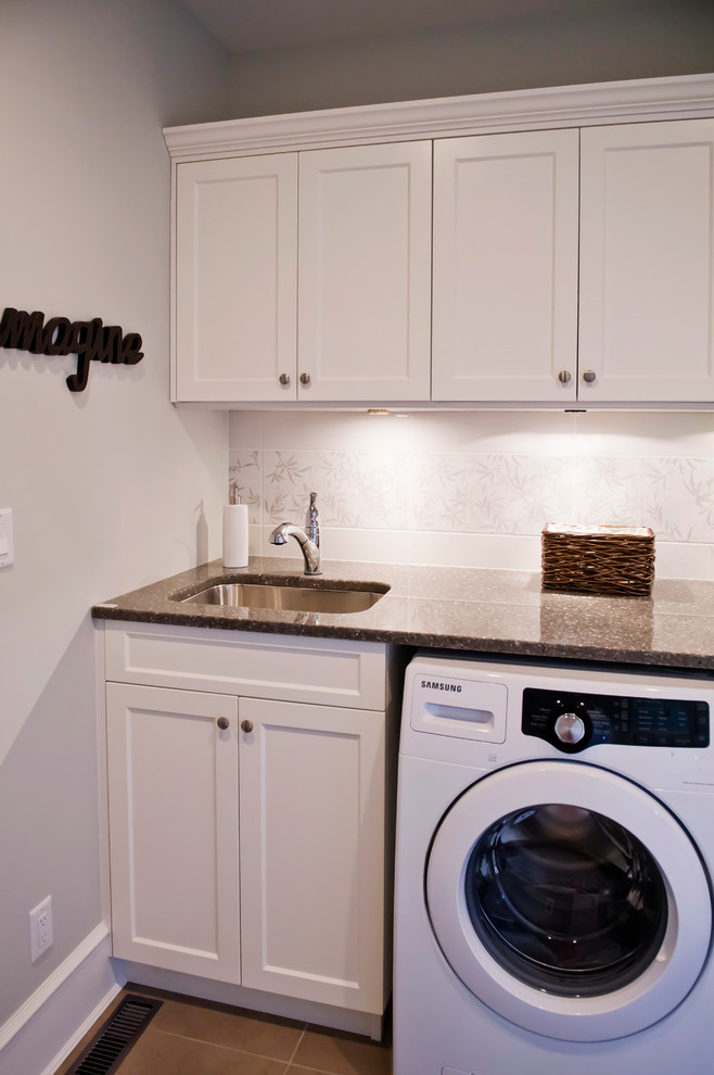 This is an example of a medium sized traditional utility room in Vancouver with a submerged sink, recessed-panel cabinets, beige walls, porcelain flooring, a side by side washer and dryer, brown floors and brown worktops.