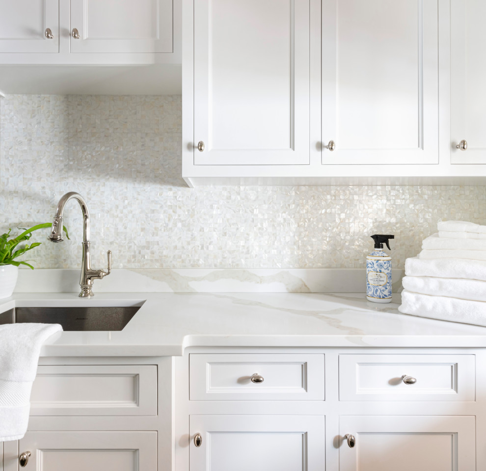 Exempel på en mellanstor klassisk vita linjär vitt tvättstuga enbart för tvätt, med en undermonterad diskho, vita skåp, bänkskiva i kvarts, vitt stänkskydd, vita väggar, klinkergolv i keramik och en tvättmaskin och torktumlare bredvid varandra
