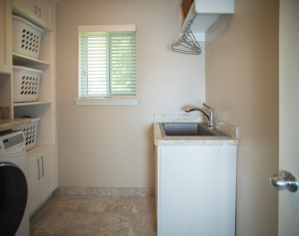 Idéer för små funkis parallella tvättstugor enbart för tvätt, med en rustik diskho, vita skåp, granitbänkskiva, beige väggar, en tvättmaskin och torktumlare bredvid varandra, beiget golv, klinkergolv i keramik och skåp i shakerstil