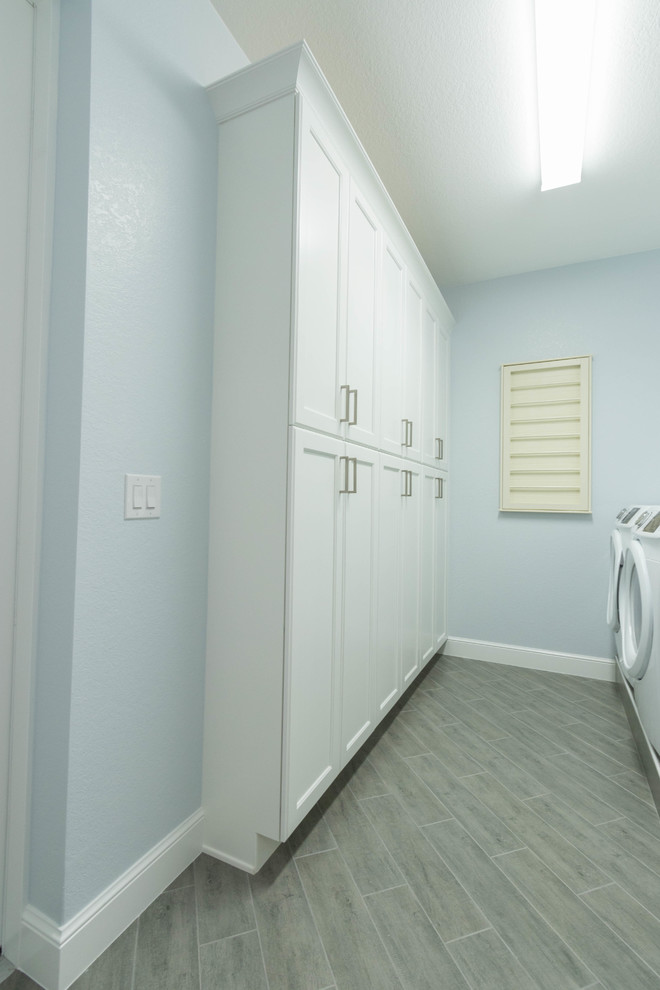 Esempio di una sala lavanderia di medie dimensioni con ante in stile shaker, ante bianche, top in granito e lavatrice e asciugatrice affiancate
