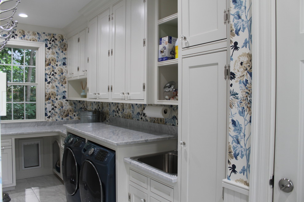 Immagine di una grande sala lavanderia country con lavatoio, ante a filo, ante bianche, top in marmo, pareti multicolore, pavimento con piastrelle in ceramica, lavatrice e asciugatrice affiancate e pavimento bianco