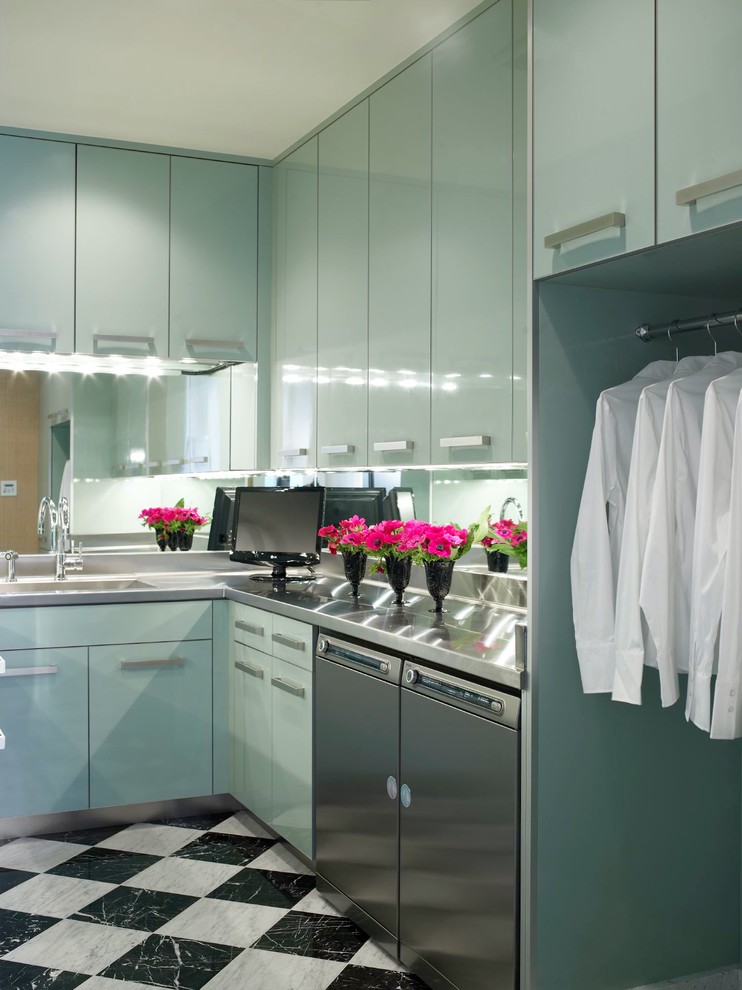 Foto de lavadero contemporáneo con armarios con paneles lisos, puertas de armario azules, lavadora y secadora juntas y encimera de acero inoxidable