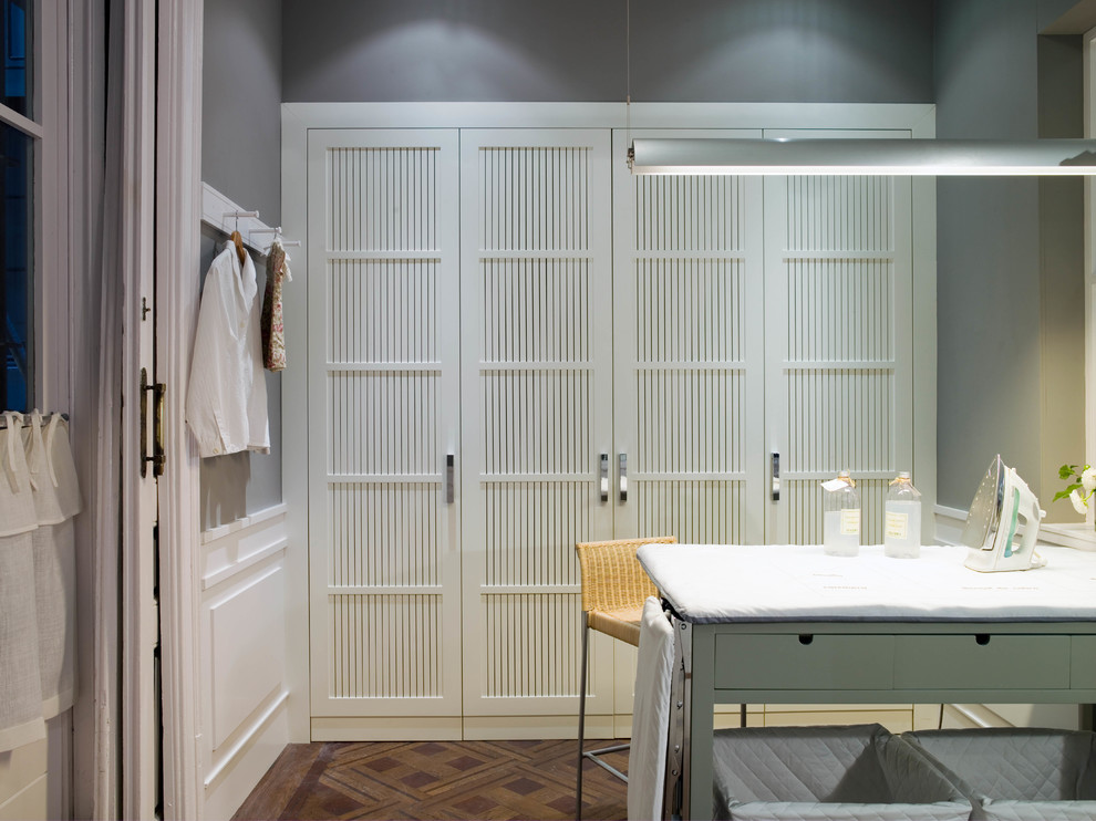 Foto de cuarto de lavado lineal escandinavo de tamaño medio con puertas de armario blancas y armarios con paneles empotrados