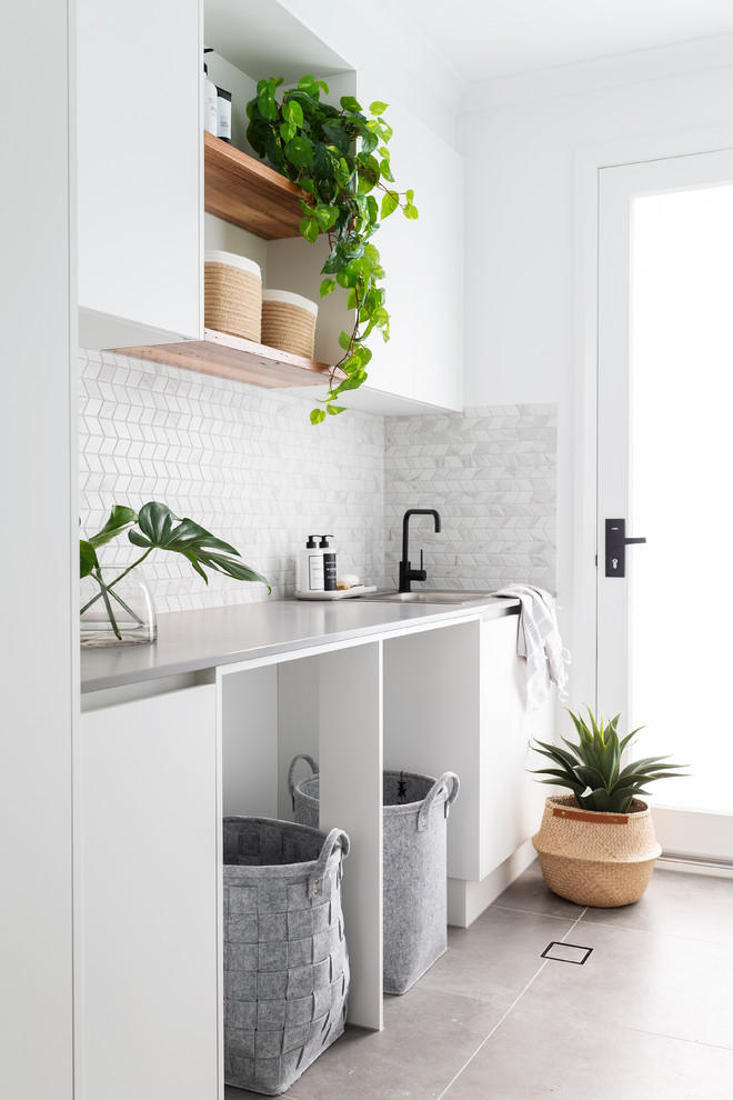 Idéer för en mellanstor modern grå linjär tvättstuga enbart för tvätt, med bänkskiva i kvarts, vita väggar, klinkergolv i porslin, en tvättpelare, grått golv, en nedsänkt diskho, släta luckor och vita skåp