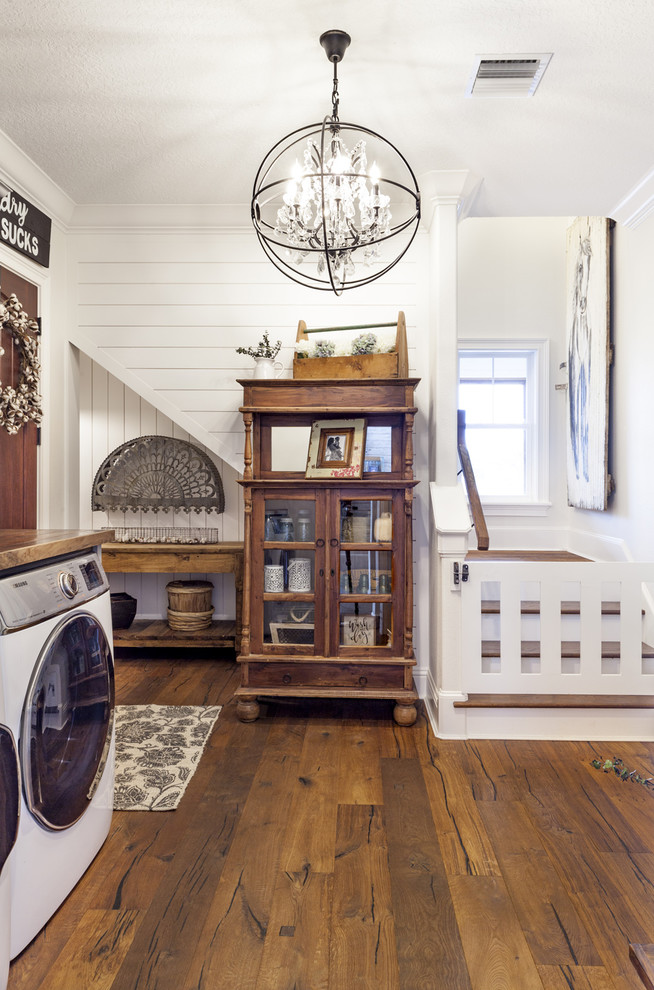 Foto di una grande lavanderia rustica con pavimento in legno massello medio, top in legno, lavatrice e asciugatrice affiancate e pavimento marrone