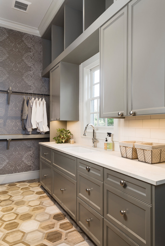 Mittelgroße Klassische Waschküche mit Unterbauwaschbecken, Schrankfronten mit vertiefter Füllung, grauen Schränken, Marmor-Arbeitsplatte, grauer Wandfarbe und Porzellan-Bodenfliesen in Austin