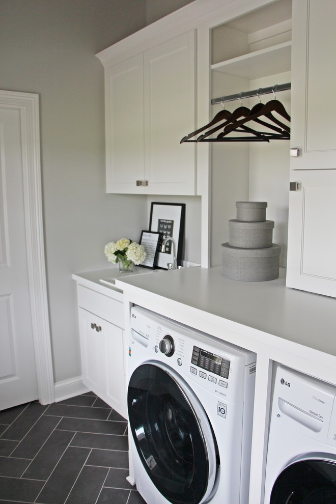 Bild på en mellanstor vintage linjär tvättstuga enbart för tvätt, med en nedsänkt diskho, skåp i shakerstil, vita skåp, bänkskiva i kvartsit, grå väggar, klinkergolv i porslin och en tvättmaskin och torktumlare bredvid varandra