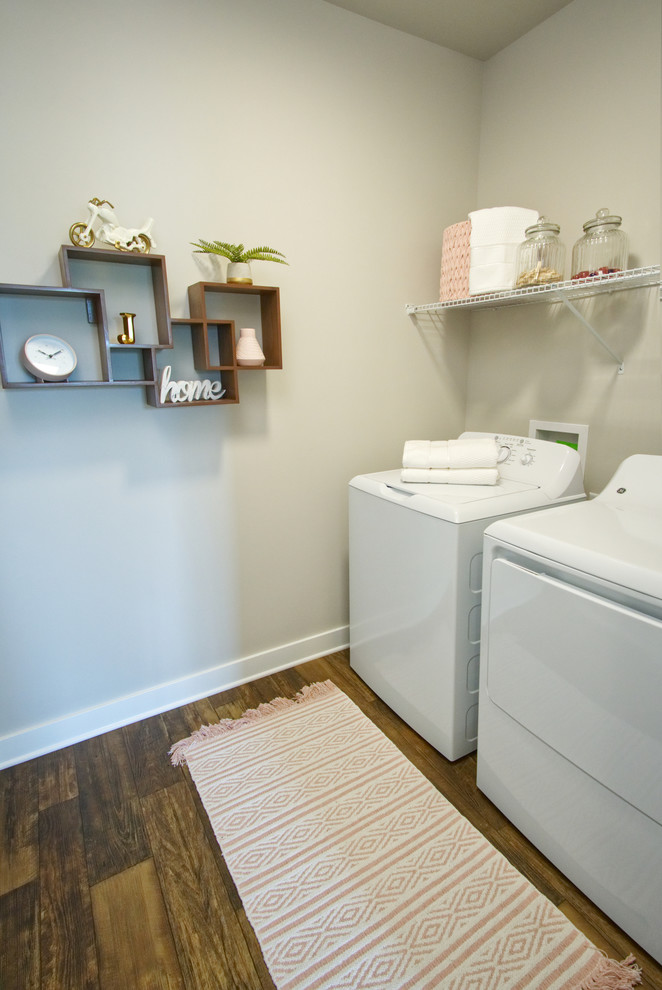 Einzeilige, Mittelgroße Urige Waschküche mit grauer Wandfarbe, braunem Holzboden, Waschmaschine und Trockner nebeneinander und braunem Boden in Louisville