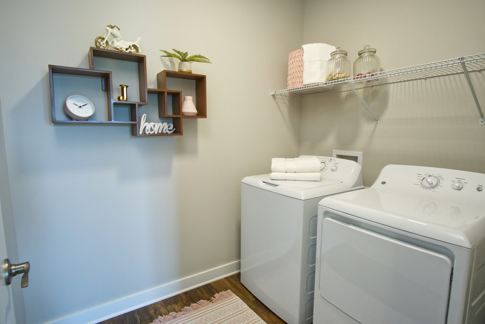 This is an example of a medium sized traditional single-wall separated utility room in Louisville with grey walls, medium hardwood flooring, a side by side washer and dryer and brown floors.