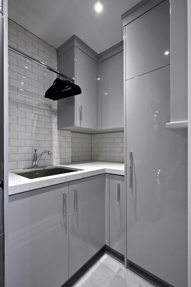 Idee per una sala lavanderia minimal di medie dimensioni con lavello sottopiano, ante lisce, ante grigie, top in laminato, pareti grigie, pavimento in gres porcellanato e pavimento grigio
