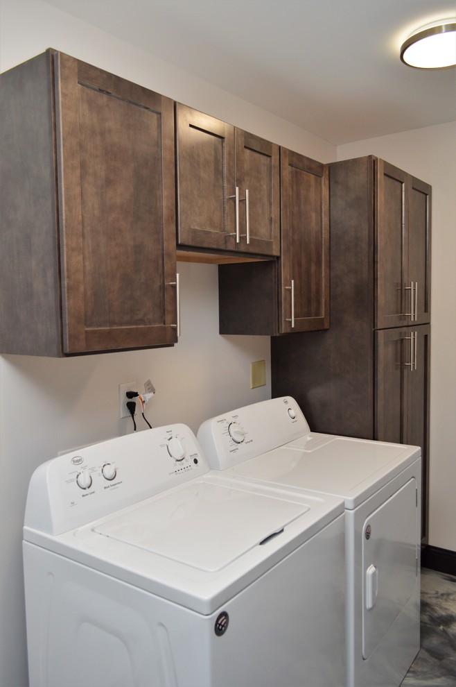 Ejemplo de cuarto de lavado lineal contemporáneo pequeño con armarios estilo shaker, puertas de armario marrones, paredes blancas y lavadora y secadora juntas