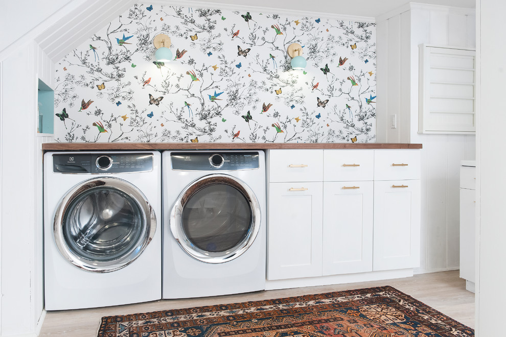 ボストンにある高級な中くらいなトランジショナルスタイルのおしゃれな家事室 (一体型シンク、落し込みパネル扉のキャビネット、白いキャビネット、木材カウンター、白い壁、淡色無垢フローリング、左右配置の洗濯機・乾燥機、ベージュの床) の写真