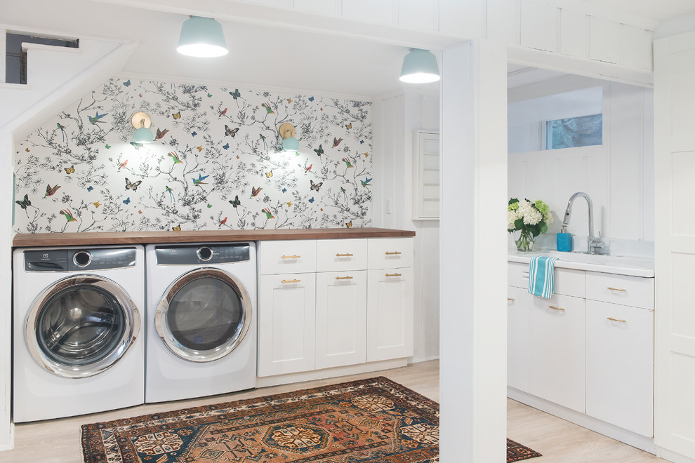 ボストンにある高級な中くらいなトランジショナルスタイルのおしゃれな家事室 (一体型シンク、落し込みパネル扉のキャビネット、白いキャビネット、木材カウンター、白い壁、淡色無垢フローリング、左右配置の洗濯機・乾燥機、ベージュの床) の写真
