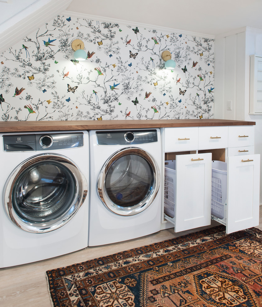 Foto di una lavanderia multiuso chic di medie dimensioni con ante con riquadro incassato, ante bianche, top in legno, pareti bianche, parquet chiaro, lavatrice e asciugatrice affiancate e pavimento beige