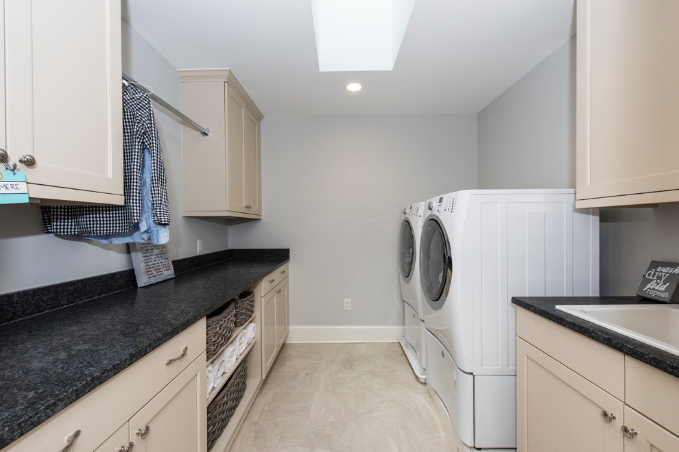 Mid-sized trendy galley ceramic tile dedicated laundry room photo in DC Metro with a drop-in sink, recessed-panel cabinets, beige cabinets, quartz countertops, blue walls and a side-by-side washer/dryer