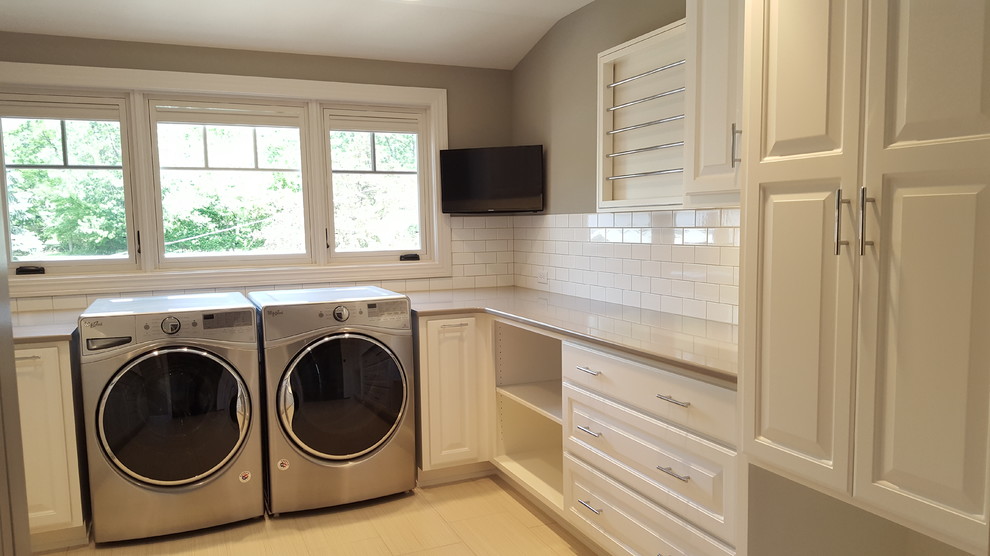 Dedicated laundry room - huge craftsman u-shaped ceramic tile and beige floor dedicated laundry room idea in Other with an undermount sink, raised-panel cabinets, white cabinets, solid surface countertops, gray walls, a side-by-side washer/dryer and beige countertops