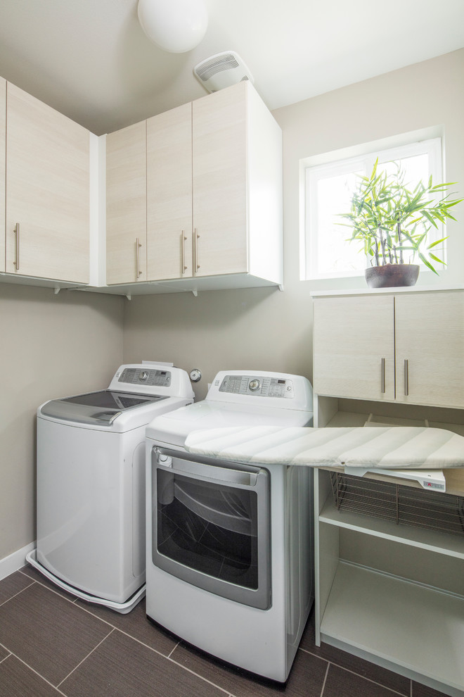 Imagen de lavadero actual con puertas de armario blancas y paredes beige