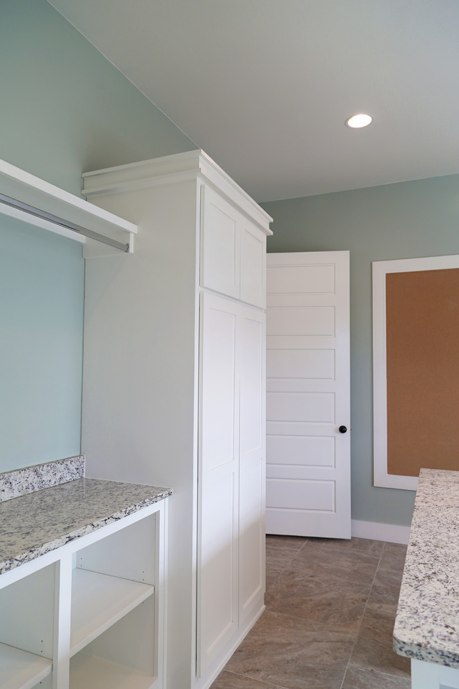 Example of a large farmhouse l-shaped ceramic tile and beige floor dedicated laundry room design in Other with an undermount sink, shaker cabinets, white cabinets, granite countertops and blue walls
