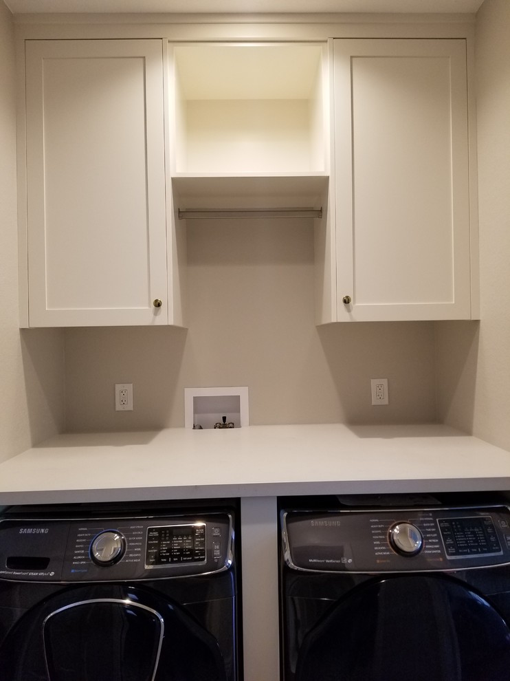 Small minimalist single-wall medium tone wood floor and brown floor laundry closet photo in Los Angeles with shaker cabinets, white cabinets, solid surface countertops, beige walls, a side-by-side washer/dryer and white countertops