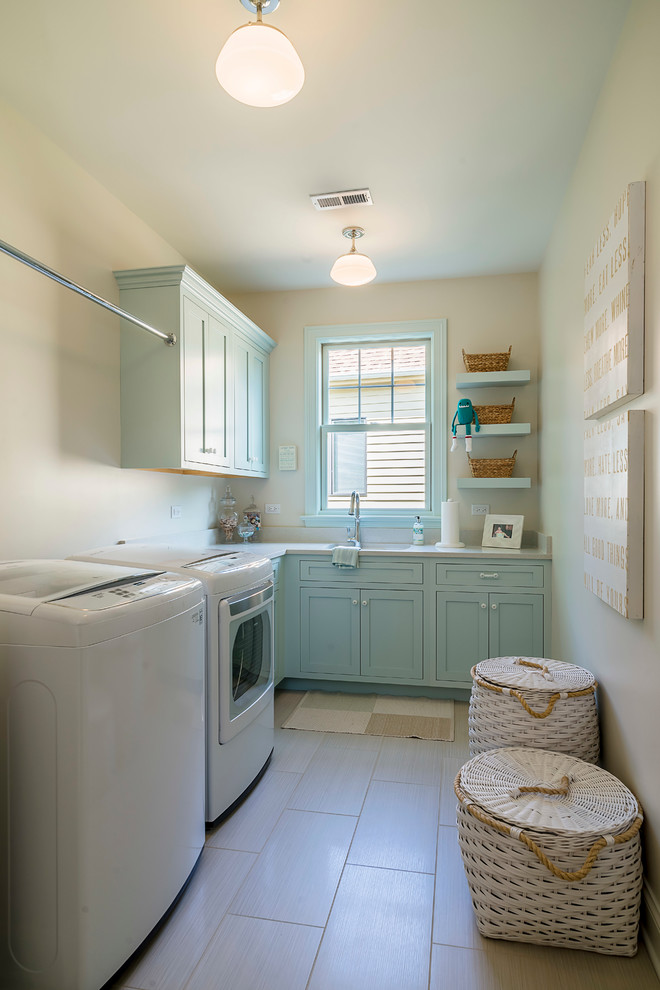 Mittelgroße Klassische Waschküche in L-Form mit Unterbauwaschbecken, Schrankfronten im Shaker-Stil, Quarzwerkstein-Arbeitsplatte, beiger Wandfarbe, Porzellan-Bodenfliesen, Waschmaschine und Trockner nebeneinander und blauen Schränken in Chicago