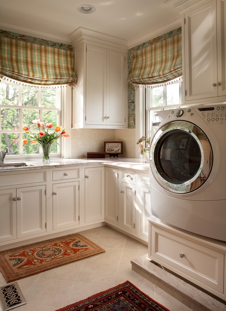 Ejemplo de lavadero clásico grande con fregadero bajoencimera, puertas de armario blancas, lavadora y secadora juntas y armarios con rebordes decorativos