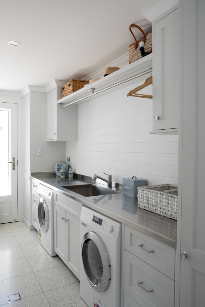 Immagine di una lavanderia classica con lavello sottopiano, ante in stile shaker, ante bianche, pareti bianche, pavimento grigio e top grigio