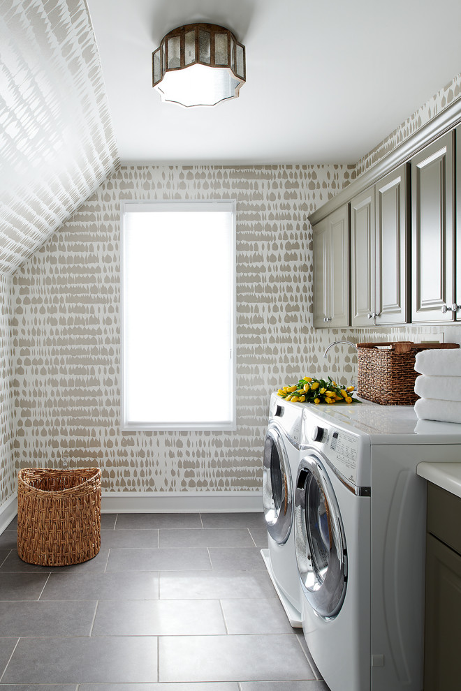Inredning av en klassisk stor vita parallell vitt tvättstuga enbart för tvätt, med luckor med upphöjd panel, grå skåp, flerfärgade väggar, klinkergolv i keramik, en tvättmaskin och torktumlare bredvid varandra och grått golv