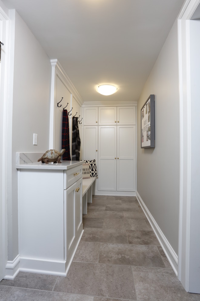 Exemple d'une buanderie chic de taille moyenne avec un placard à porte shaker, des portes de placard blanches, un plan de travail en quartz, un mur gris, un sol en carrelage de porcelaine, un sol gris et un plan de travail blanc.