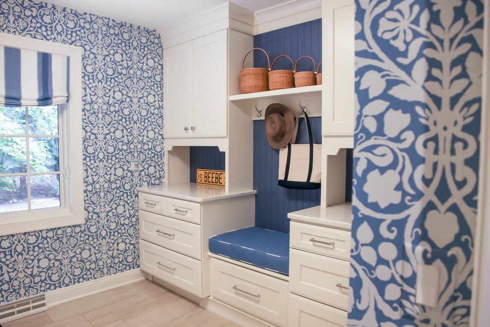 Exempel på en mellanstor klassisk parallell tvättstuga enbart för tvätt, med en undermonterad diskho, luckor med infälld panel, vita skåp, bänkskiva i kvarts, blå väggar, ljust trägolv och en tvättmaskin och torktumlare bredvid varandra