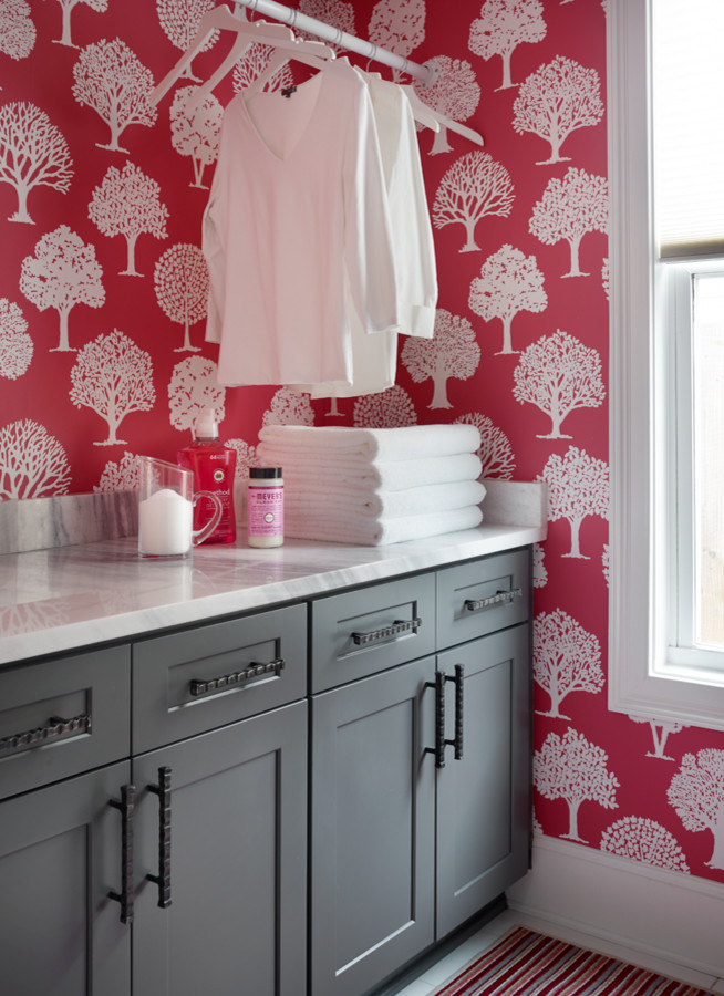Inredning av en klassisk mellanstor parallell tvättstuga enbart för tvätt, med skåp i shakerstil, grå skåp, marmorbänkskiva, klinkergolv i porslin, en tvättmaskin och torktumlare bredvid varandra och röda väggar