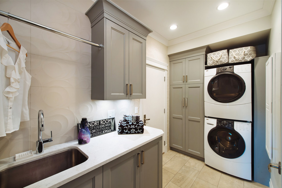 Mittelgroße Klassische Waschküche mit Unterbauwaschbecken, grauen Schränken, Quarzwerkstein-Arbeitsplatte, grauer Wandfarbe, Porzellan-Bodenfliesen, Waschmaschine und Trockner gestapelt und Schrankfronten im Shaker-Stil in Vancouver