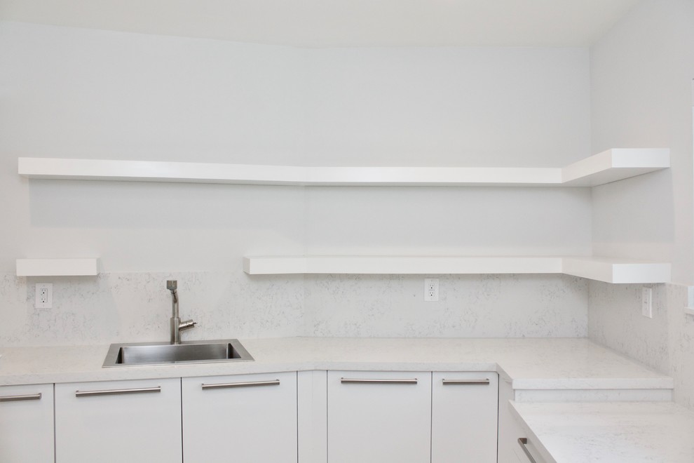 This is an example of a large modern galley utility room in Miami with an utility sink, flat-panel cabinets, white cabinets, engineered stone countertops, white walls, marble flooring and a side by side washer and dryer.