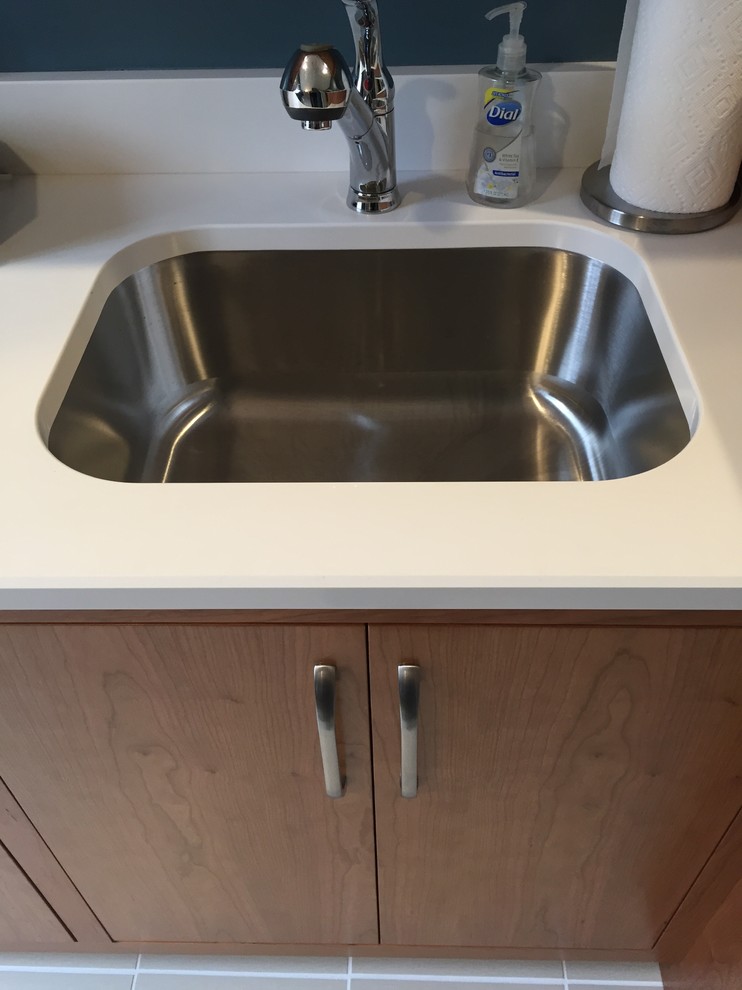 Photo of a large classic u-shaped separated utility room in Chicago with a submerged sink, flat-panel cabinets, medium wood cabinets, engineered stone countertops, blue walls, ceramic flooring and a side by side washer and dryer.