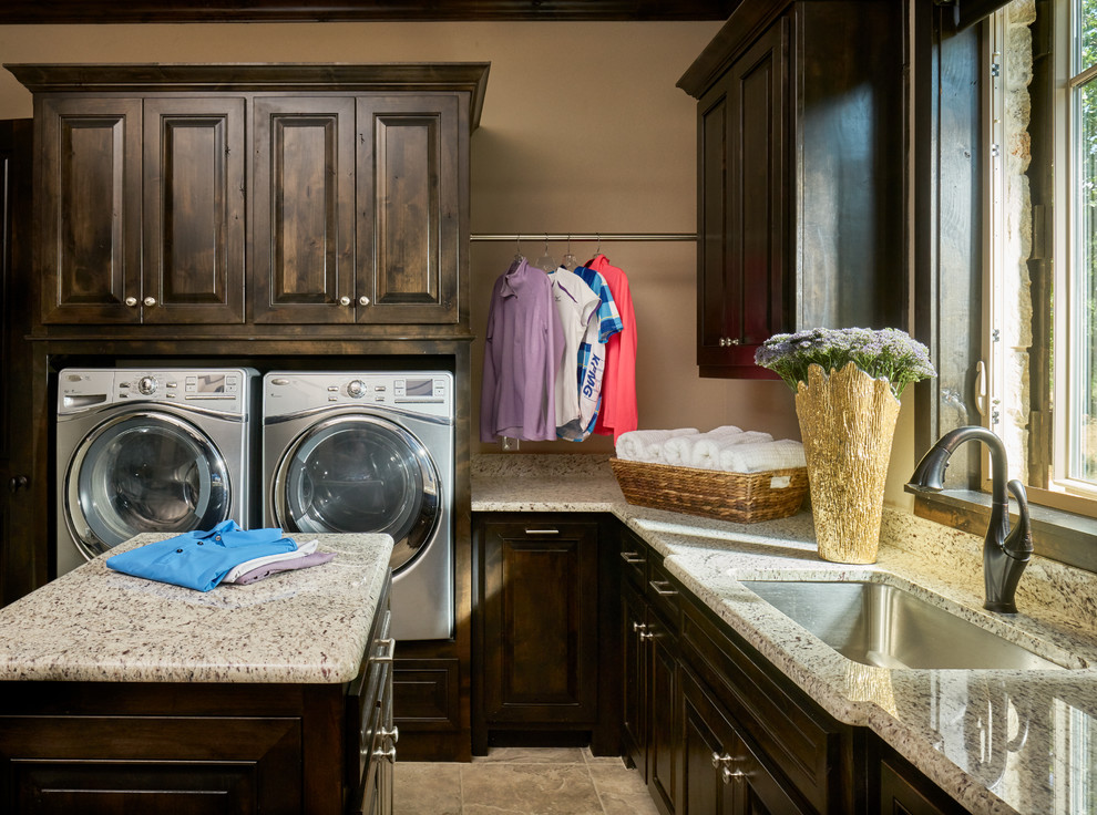 Inspiration for a large classic u-shaped utility room in Other with a submerged sink, raised-panel cabinets, dark wood cabinets, granite worktops, beige walls, ceramic flooring, a side by side washer and dryer and beige floors.
