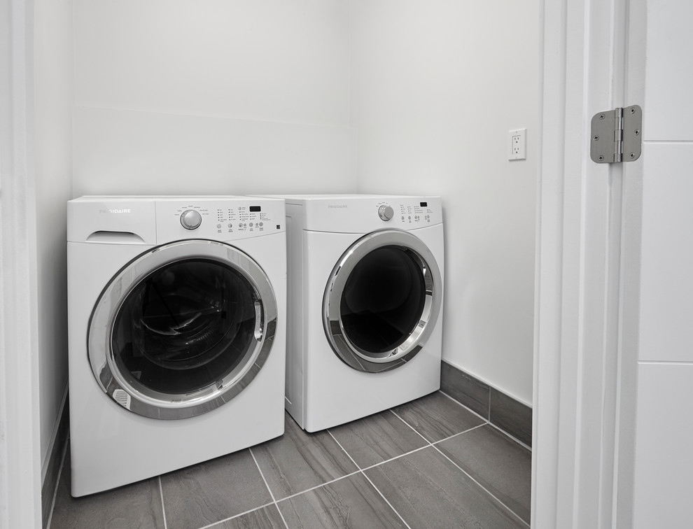Ispirazione per una piccola sala lavanderia minimalista con pareti bianche, pavimento in gres porcellanato e lavatrice e asciugatrice affiancate