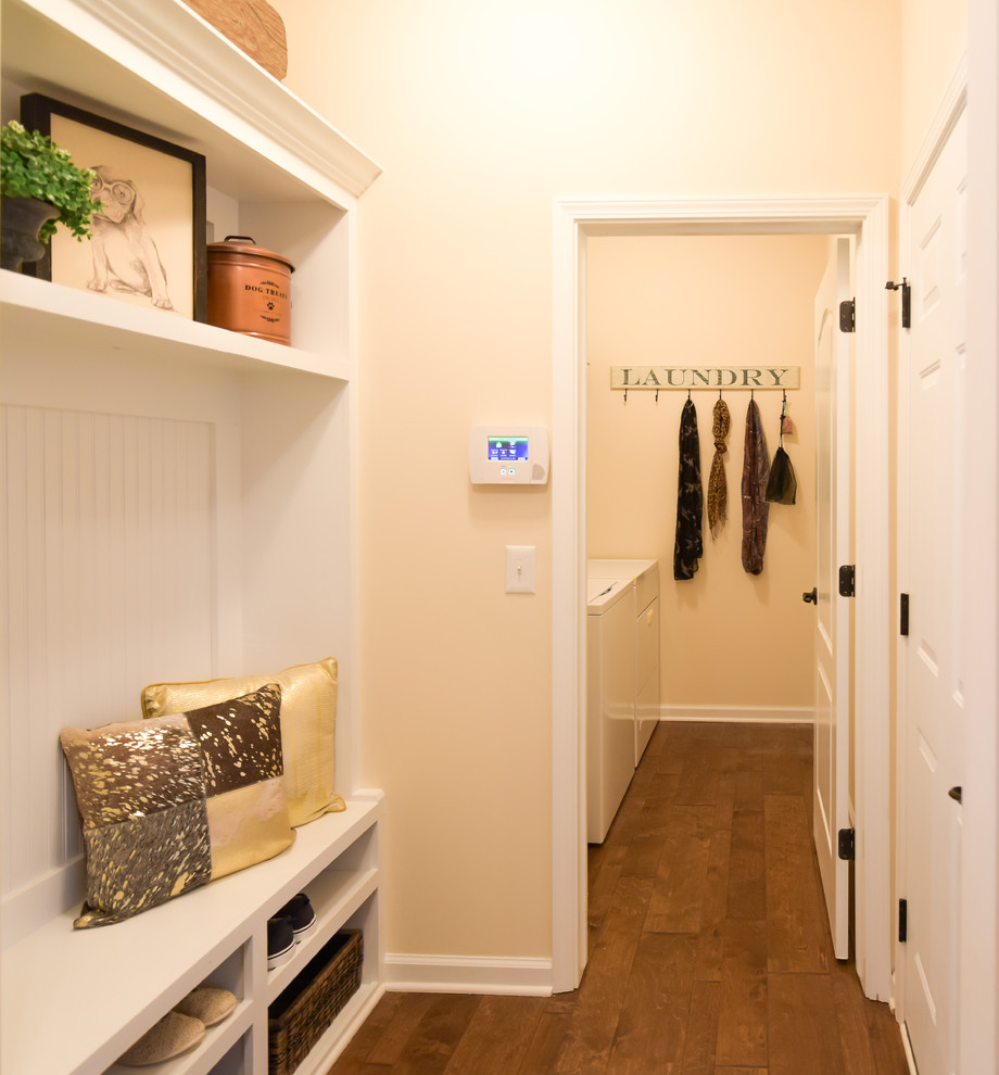 Design ideas for a small traditional single-wall utility room in Detroit with light wood cabinets, dark hardwood flooring, beige walls and a side by side washer and dryer.