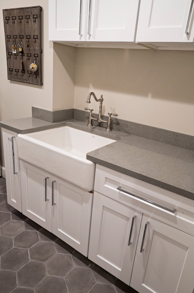 Transitional galley concrete floor dedicated laundry room photo in Other with a farmhouse sink, shaker cabinets, white cabinets, quartz countertops, gray walls and a side-by-side washer/dryer