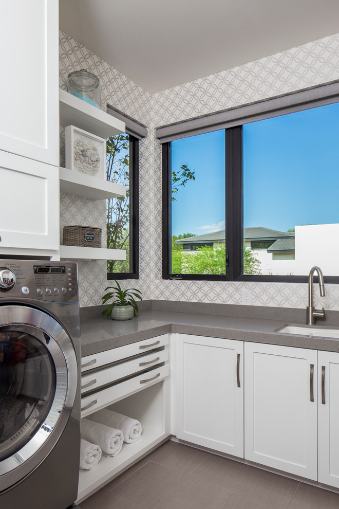 Moderner Hauswirtschaftsraum mit weißen Schränken und Waschmaschine und Trockner nebeneinander in Austin